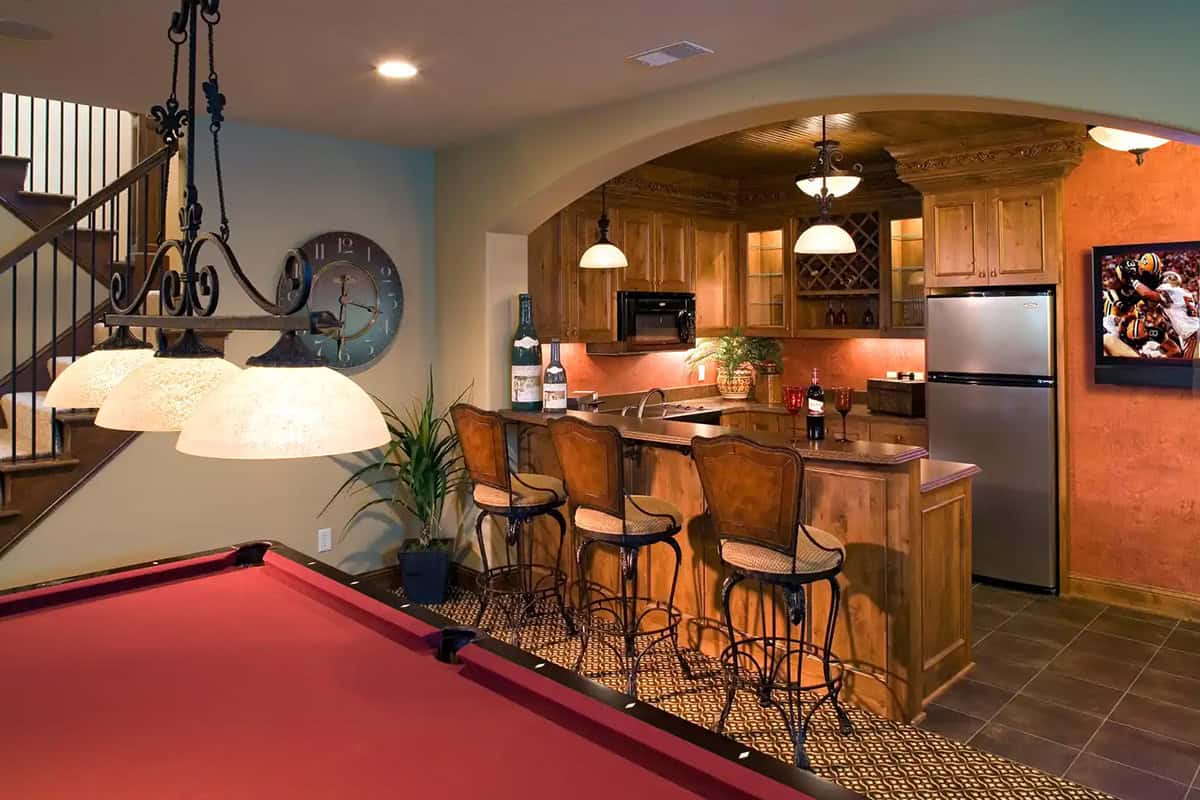 Wet bar with wine storage and wall-mounted TV near pool table