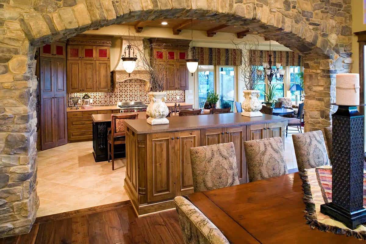 Kitchen island view through stone archway into dining area