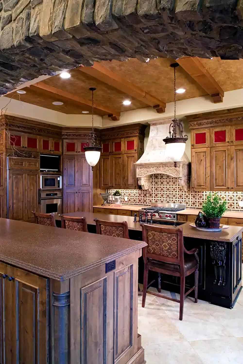 Kitchen with dual islands under exposed stone and wood beam ceiling