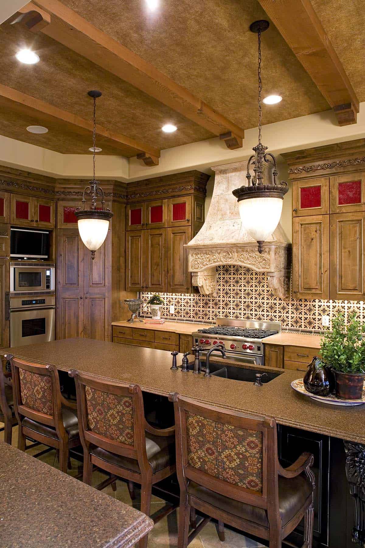 Kitchen island with gas range and hand-carved stone vent hood