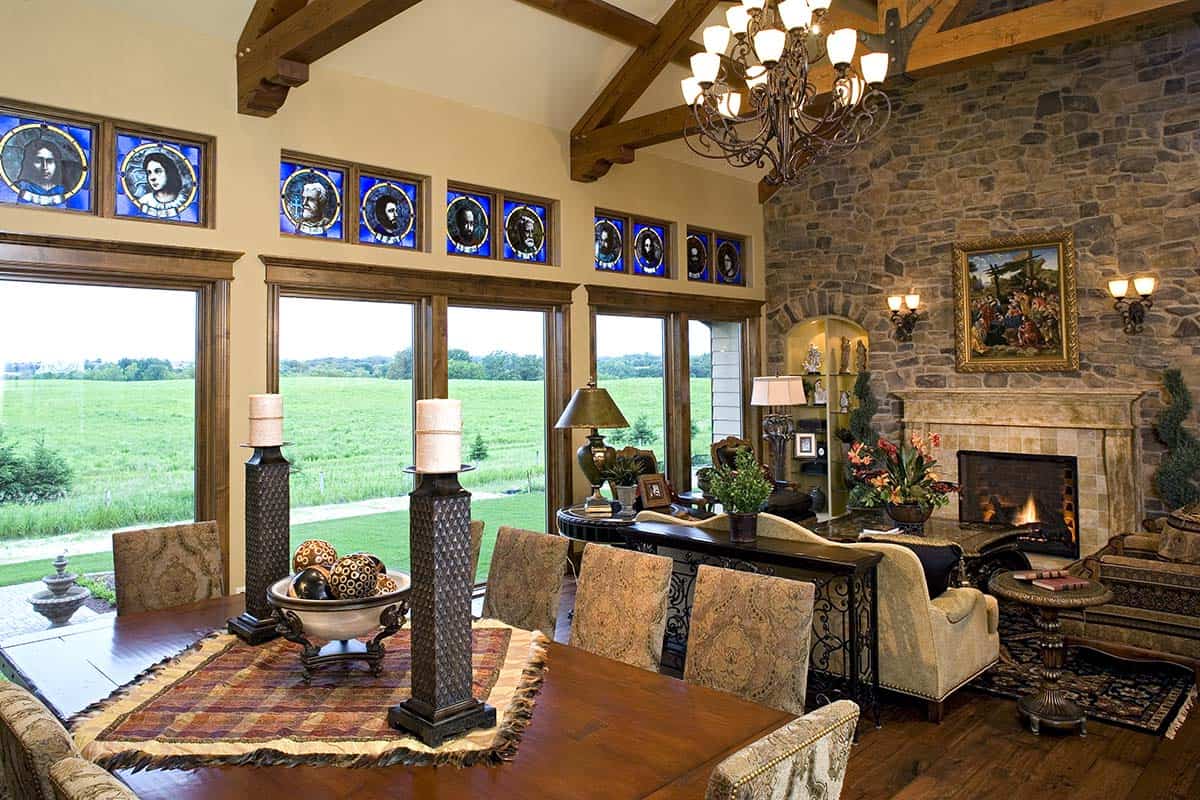 Dining table set beneath vaulted wood beam ceiling with fireplace view