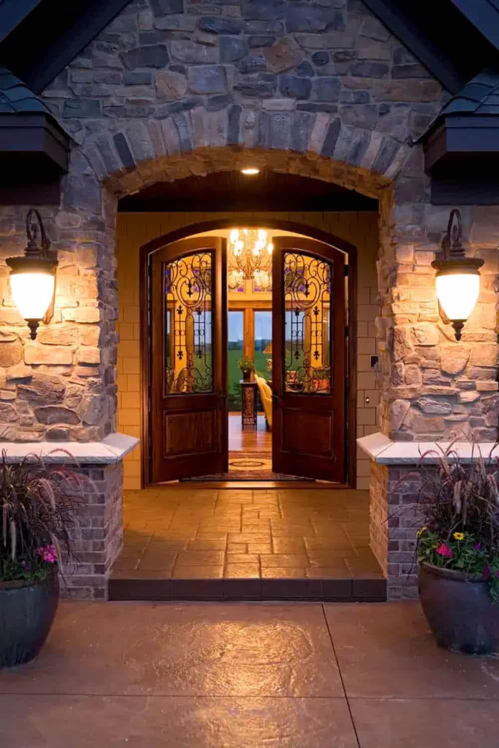 Front entry door with wrought iron glass panels lit at dusk