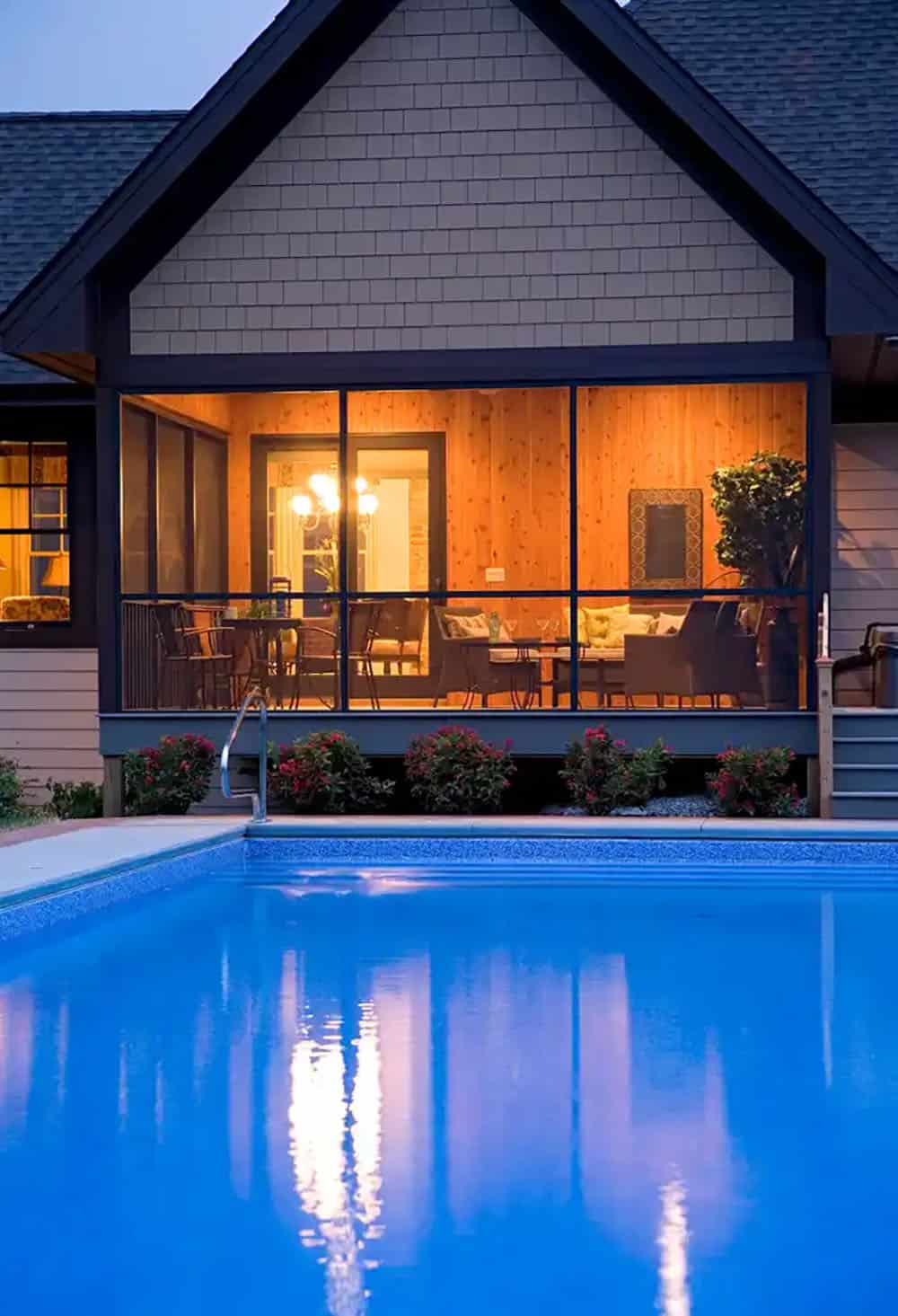 Screened porch reflected in pool water at twilight