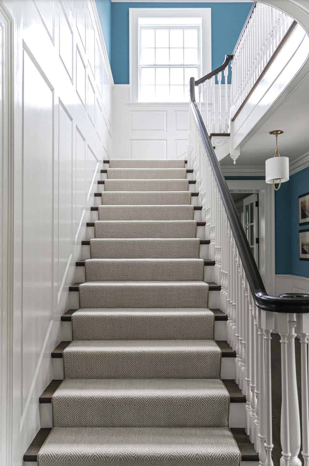 Straight staircase run with diamond-pattern runner and dark wood handrail