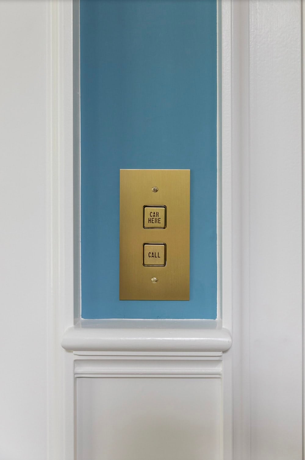 Image 16: Vintage brass elevator call panel with "Car Here" and "Call" buttons on a blue recessed wall