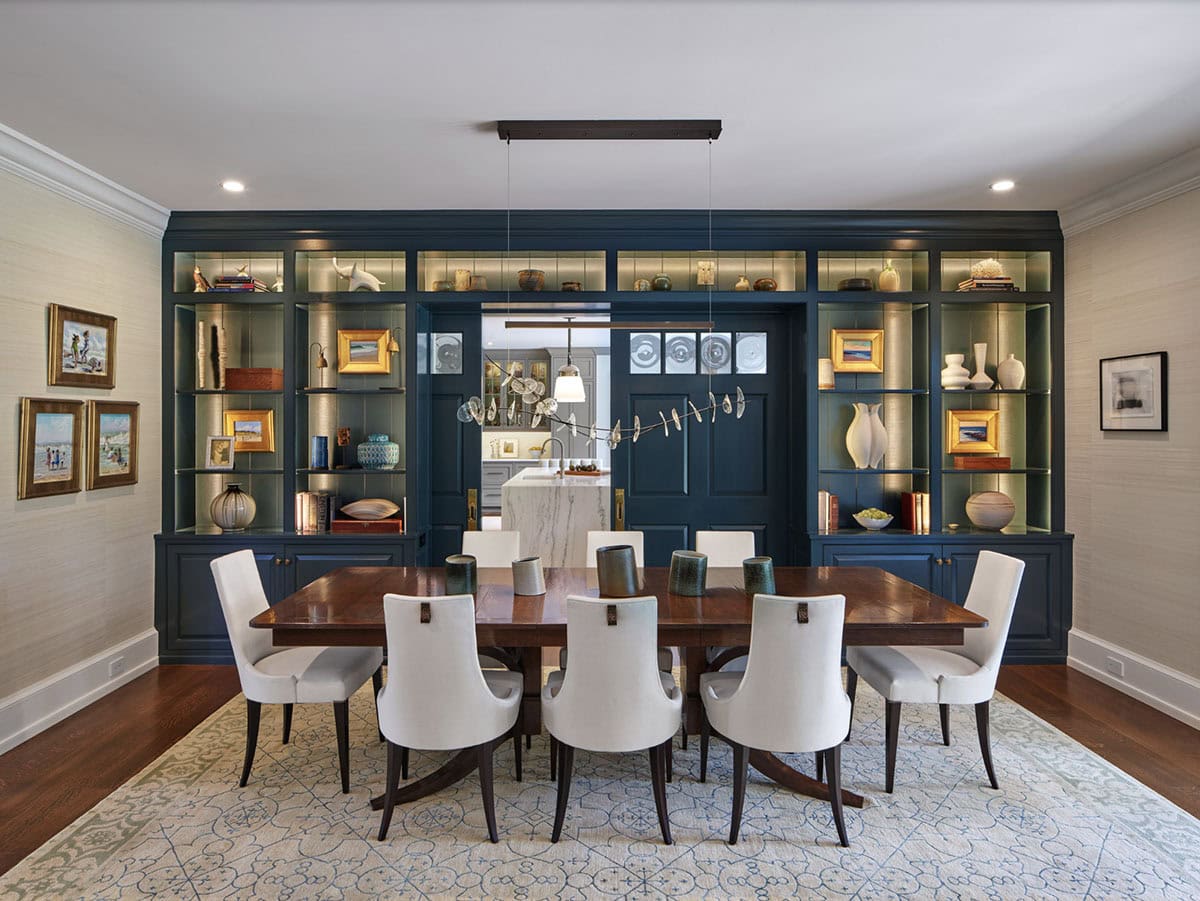 Alternate angle of the navy-shelved dining room with kitchen visible through open doors