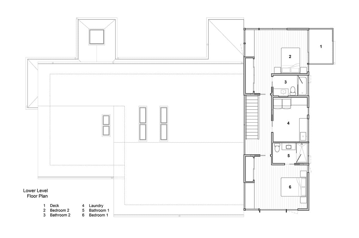 Architectural floor plan of the upper level showing two bedrooms, bathrooms, laundry, and deck