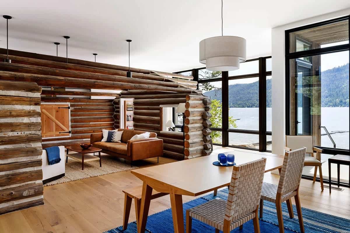 Open living and dining area built around an original log cabin core, with lake views through glass doors