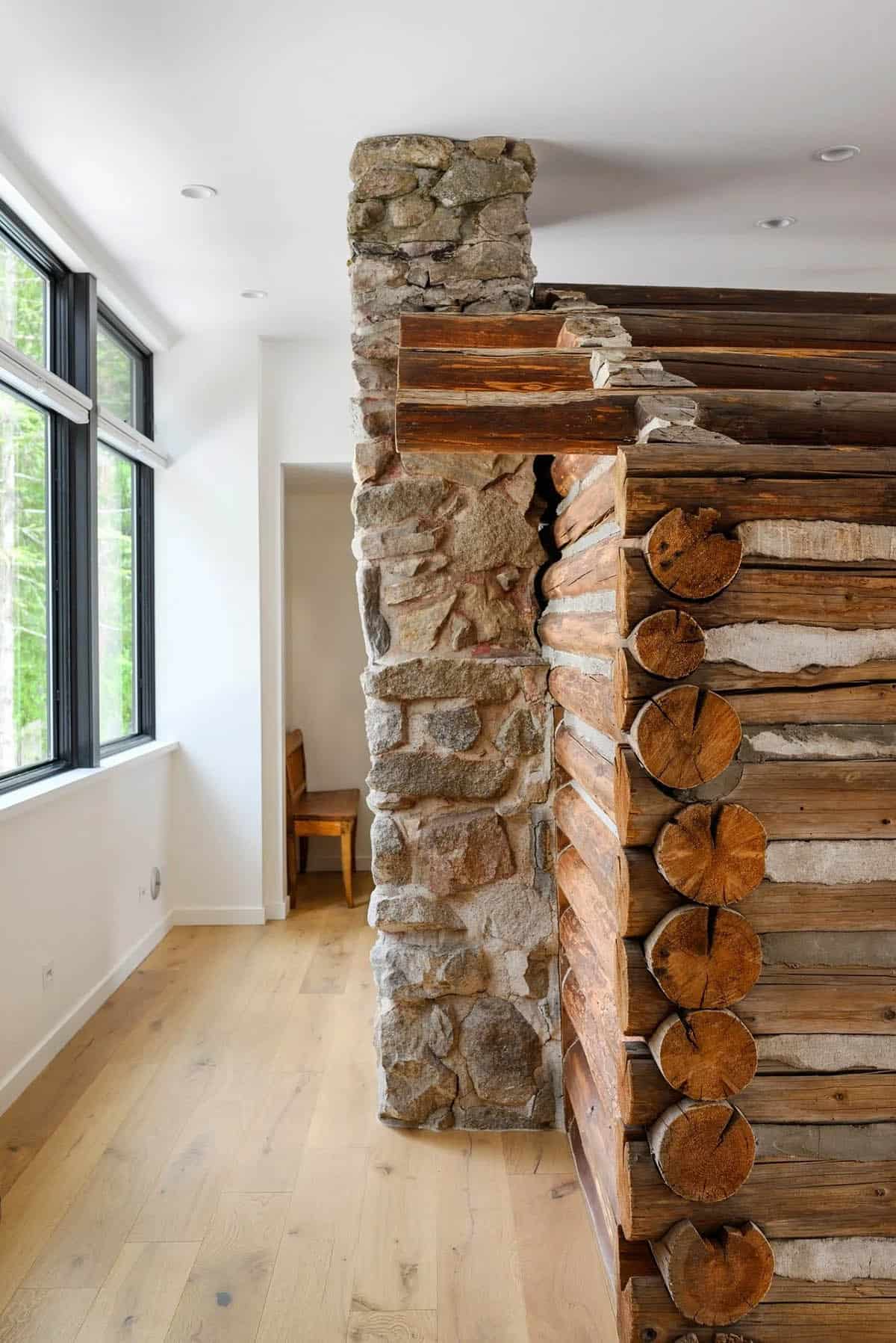 Close-up of log cabin corner notching next to a stone chimney column