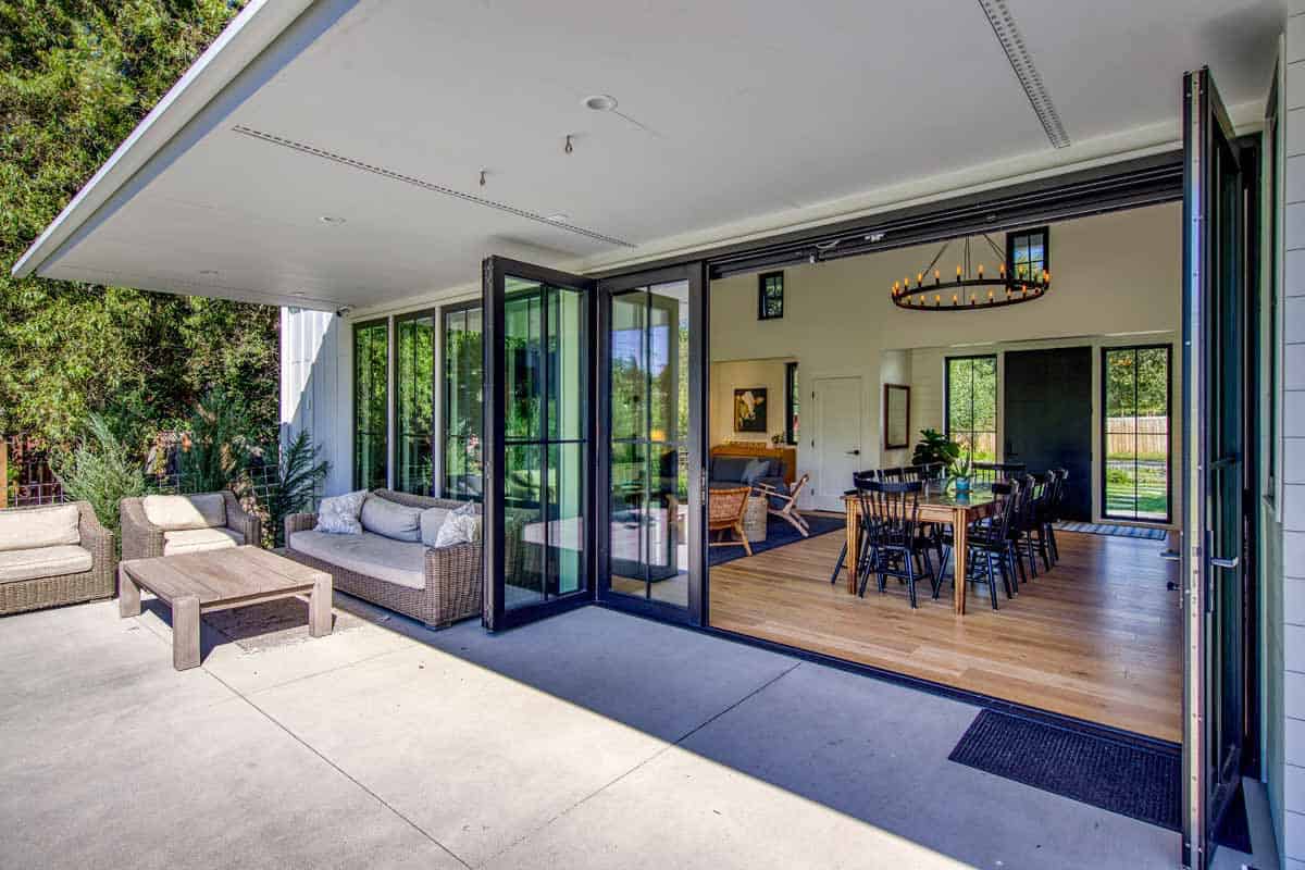 Covered patio seating area looking through open folding glass doors into the dining room