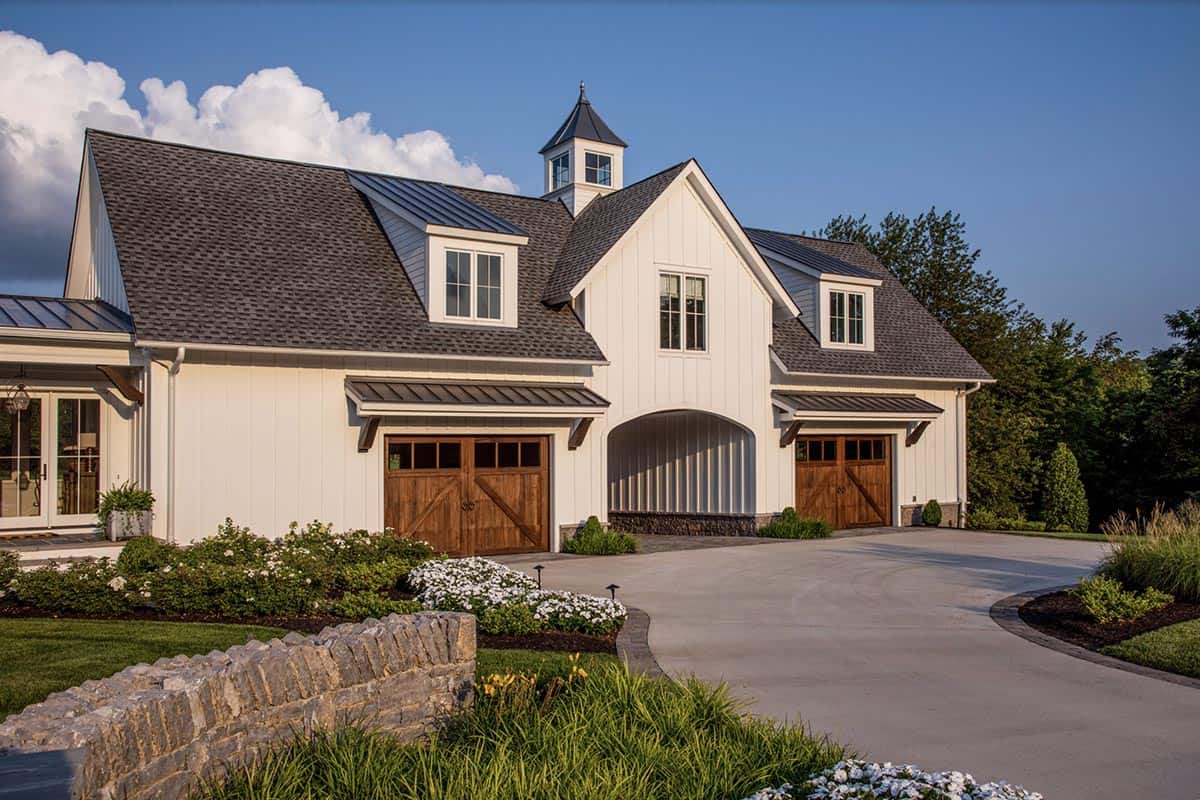 Close-up of the garage building with cupola, dormers, and wooden garage doors