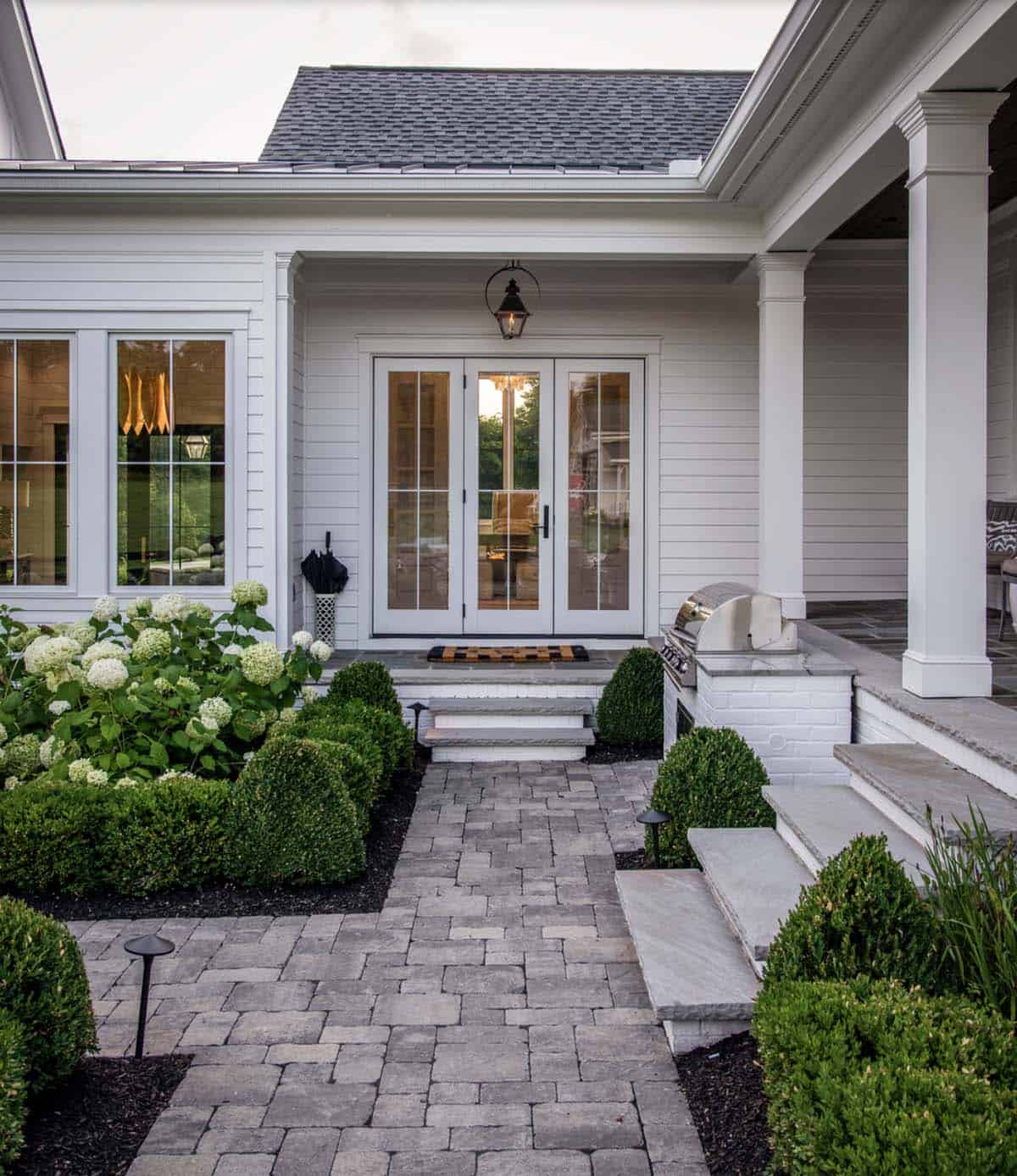 Side porch entry with outdoor grill, French doors, and boxwood landscaping