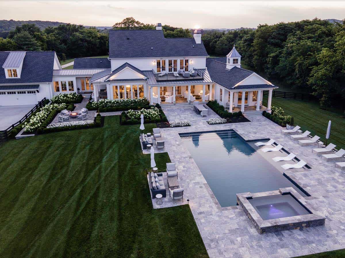 Aerial dusk view of the backyard pool, spa, patio, and porches