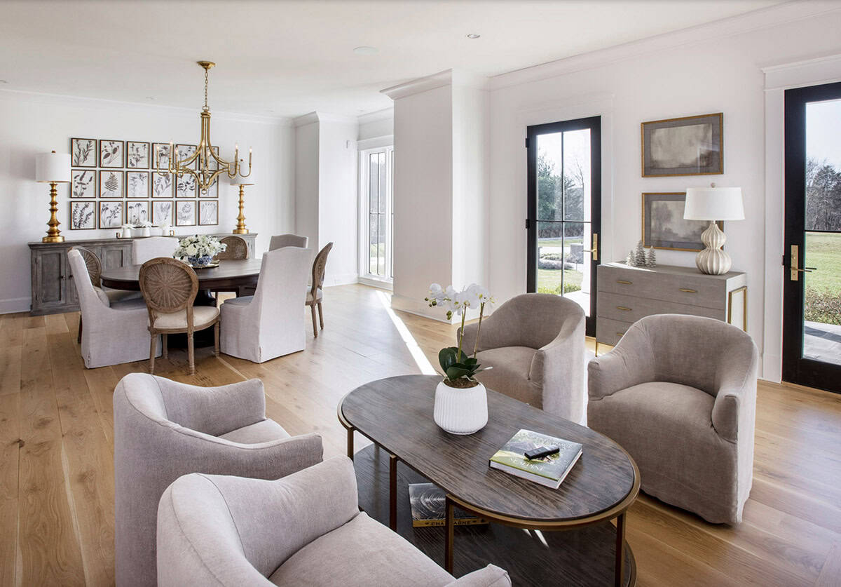 Sitting area with round dining table, gray armchairs, and gallery wall
