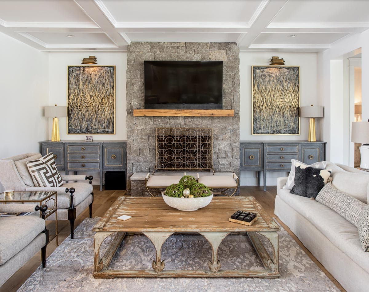Living room with stone fireplace, wood coffee table, and gray built-in cabinets