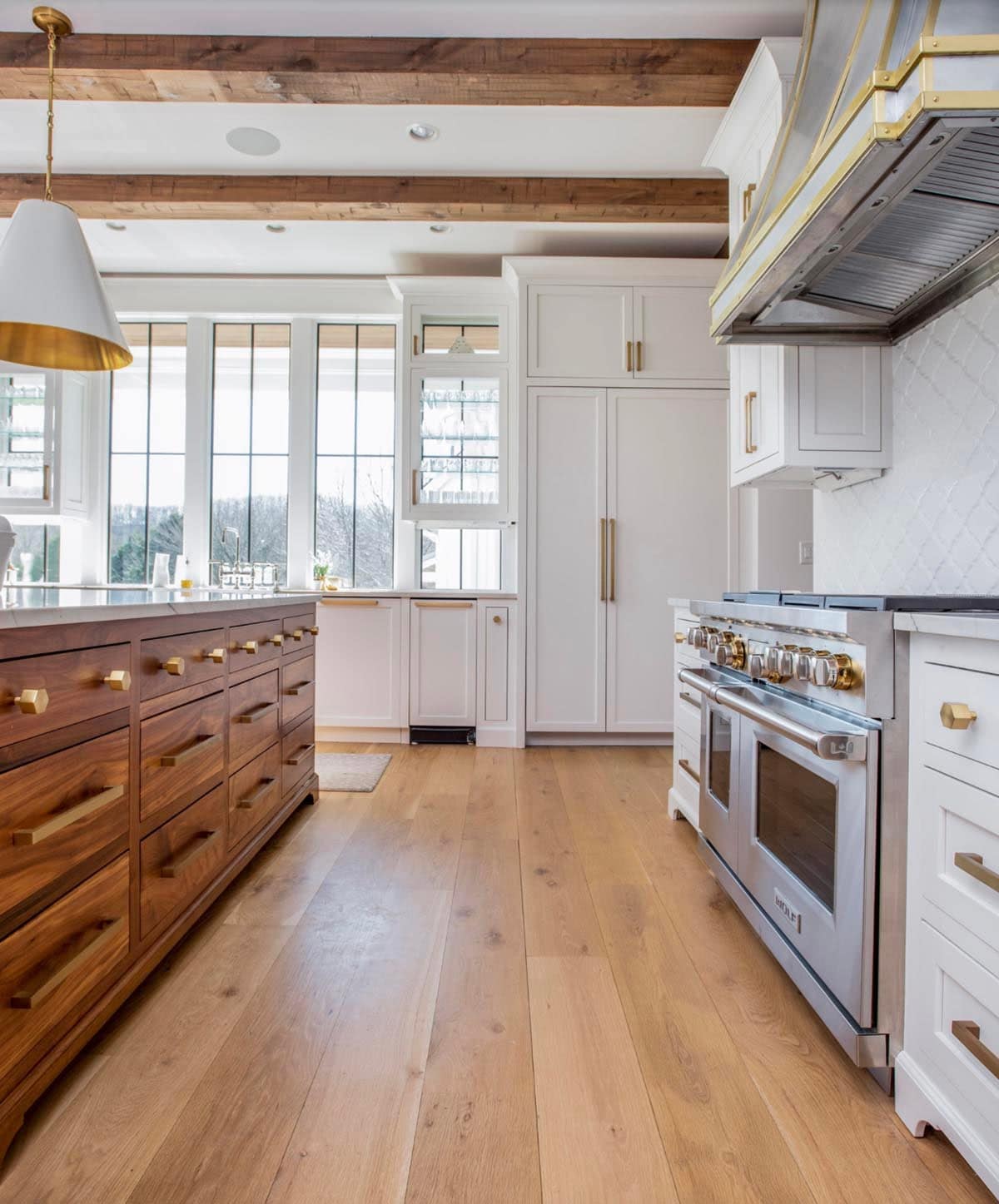 Kitchen view with walnut island, brass hardware, and stainless range