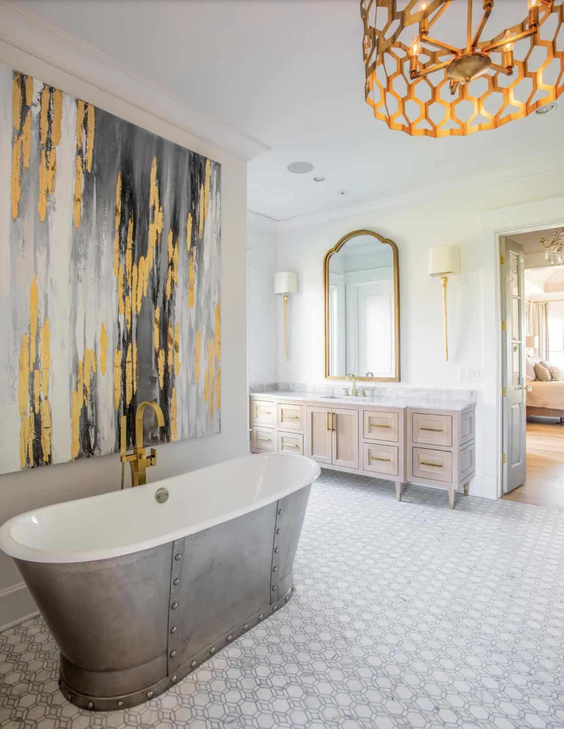 Primary bathroom with freestanding metal soaking tub and gold honeycomb chandelier