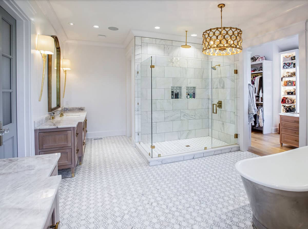 Primary bathroom with glass-enclosed marble shower and view into walk-in closet