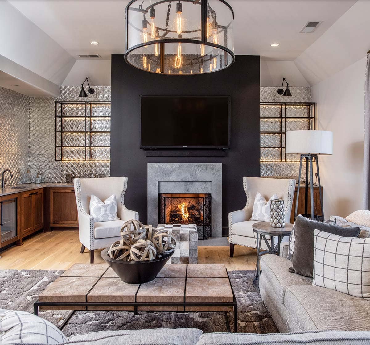 Media room with dark accent wall, stone fireplace, and mounted TV