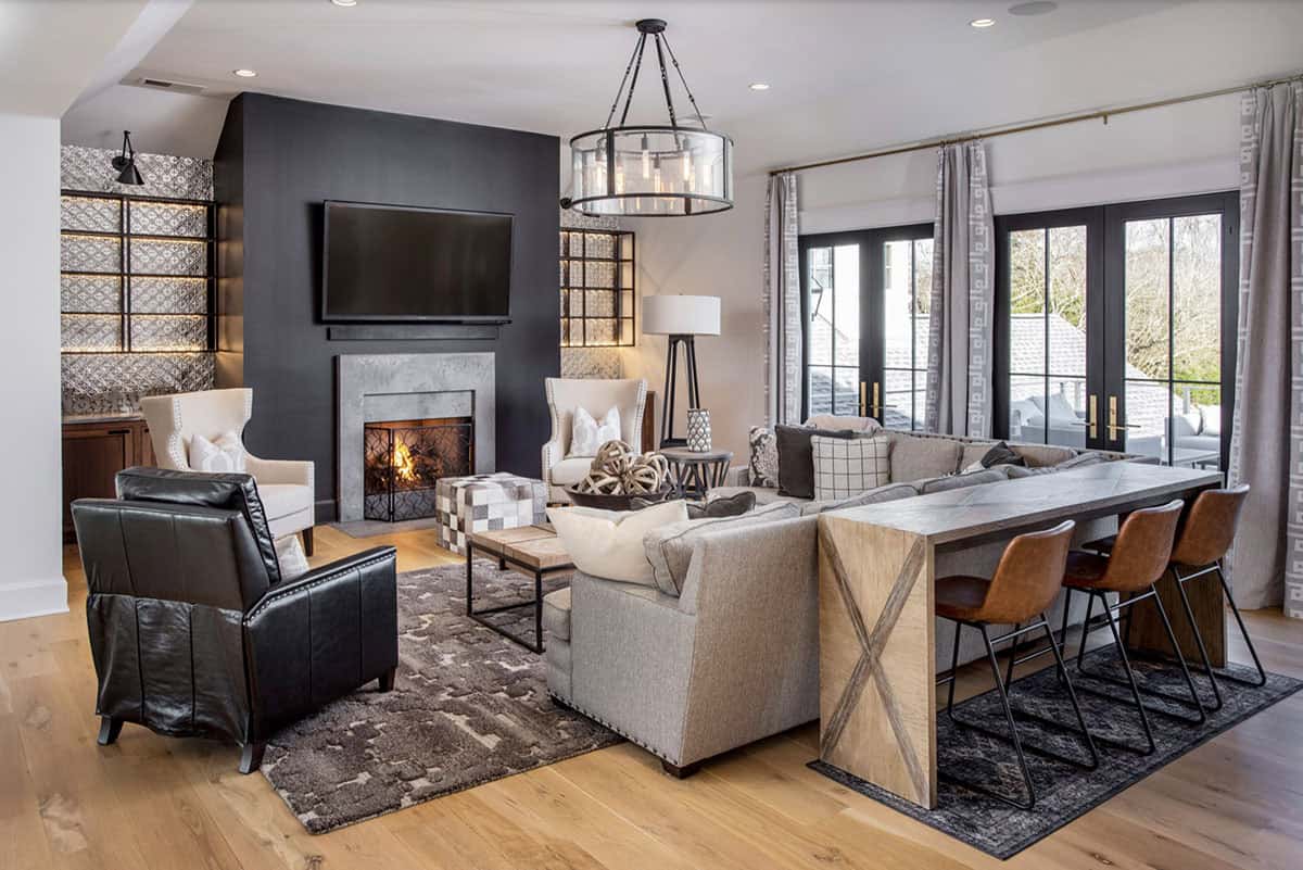 Media room seating area with sectional sofa, fireplace, and bar-height table