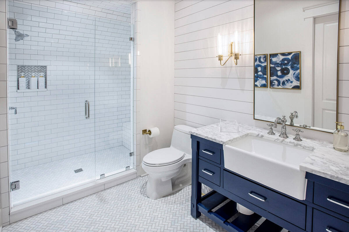 Bathroom with navy vanity, subway tile shower, and blue abstract artwork