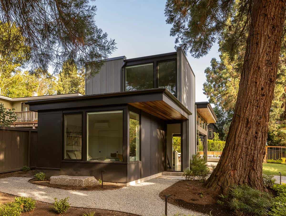 Dark wood-clad bedroom wing with a boulder accent and sequoia trunk in front