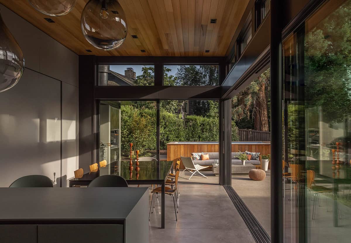 Kitchen island view through open glass doors to the dining table and patio