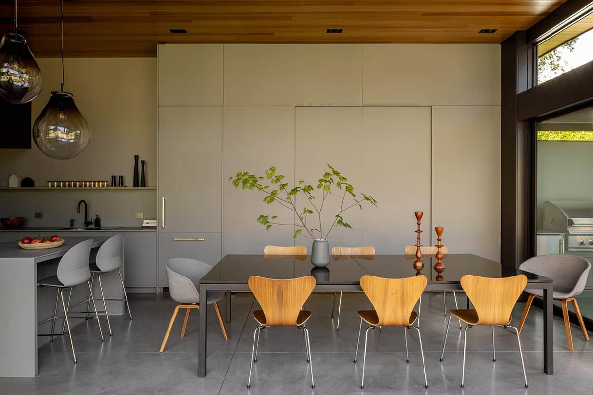 Centered view of the dining table, tall cabinetry wall, and cedar ceiling
