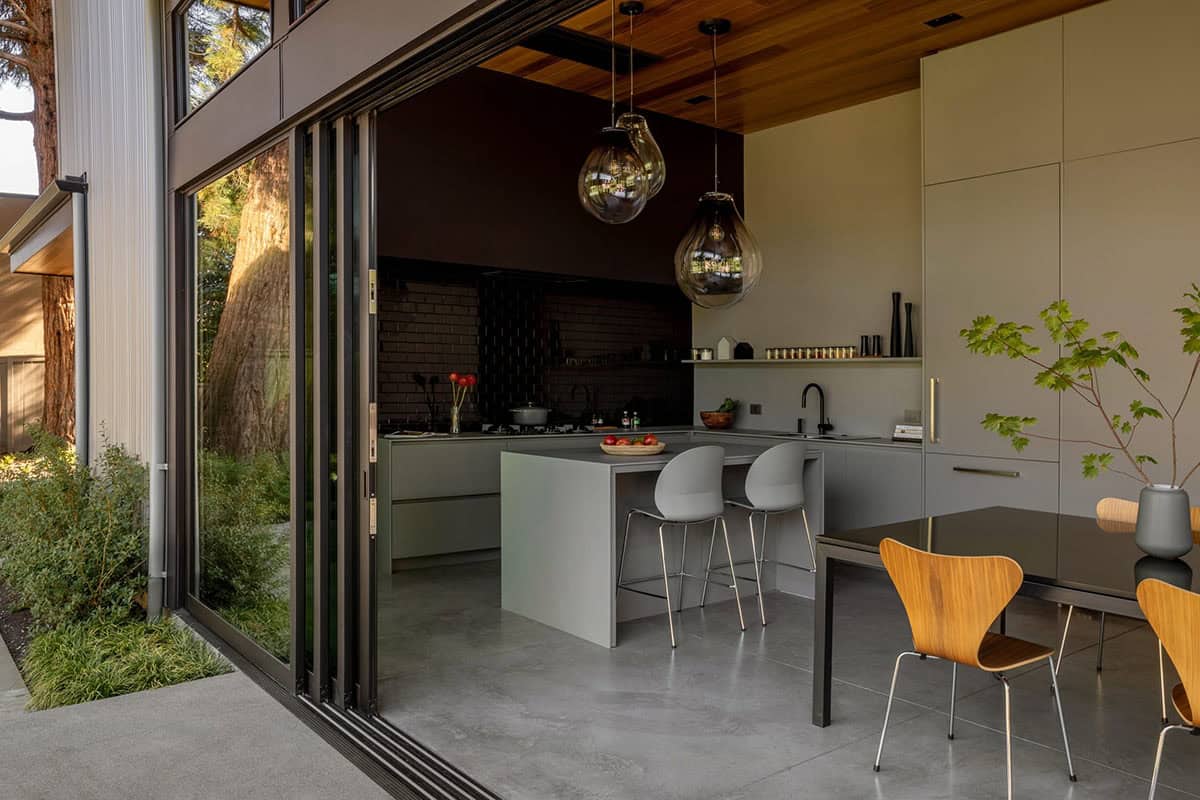 Open folding glass doors linking the patio to the kitchen and dining area
