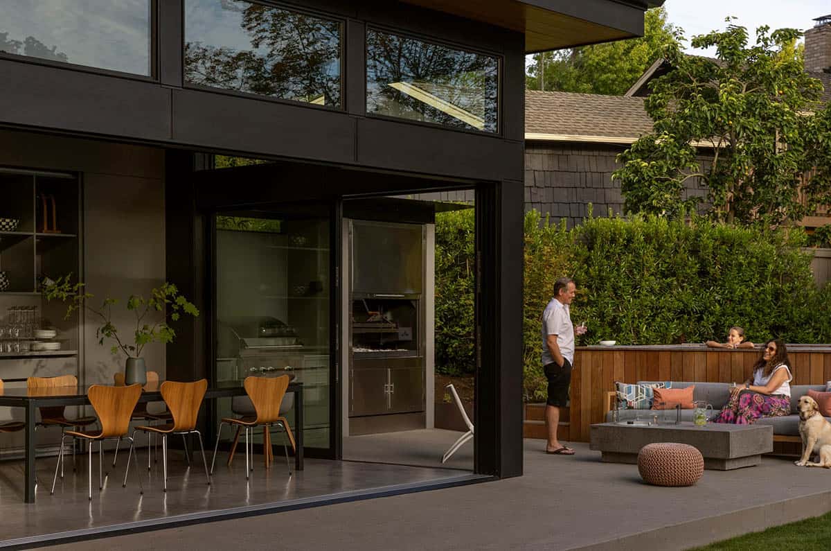 People relaxing on the patio and in the hot tub near the open dining pavilion