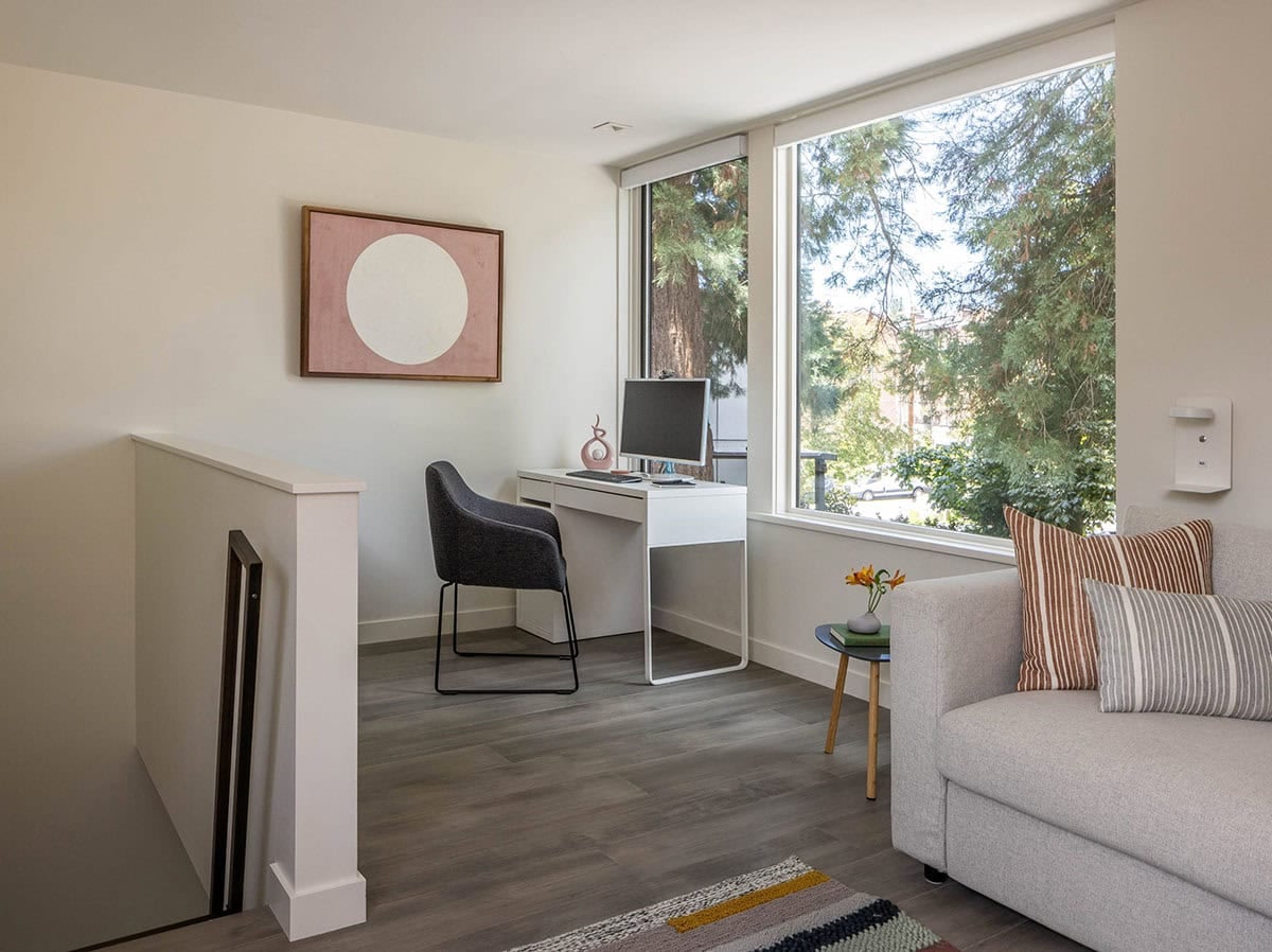Small upstairs office nook with a white desk, chair, and sequoia-view windows