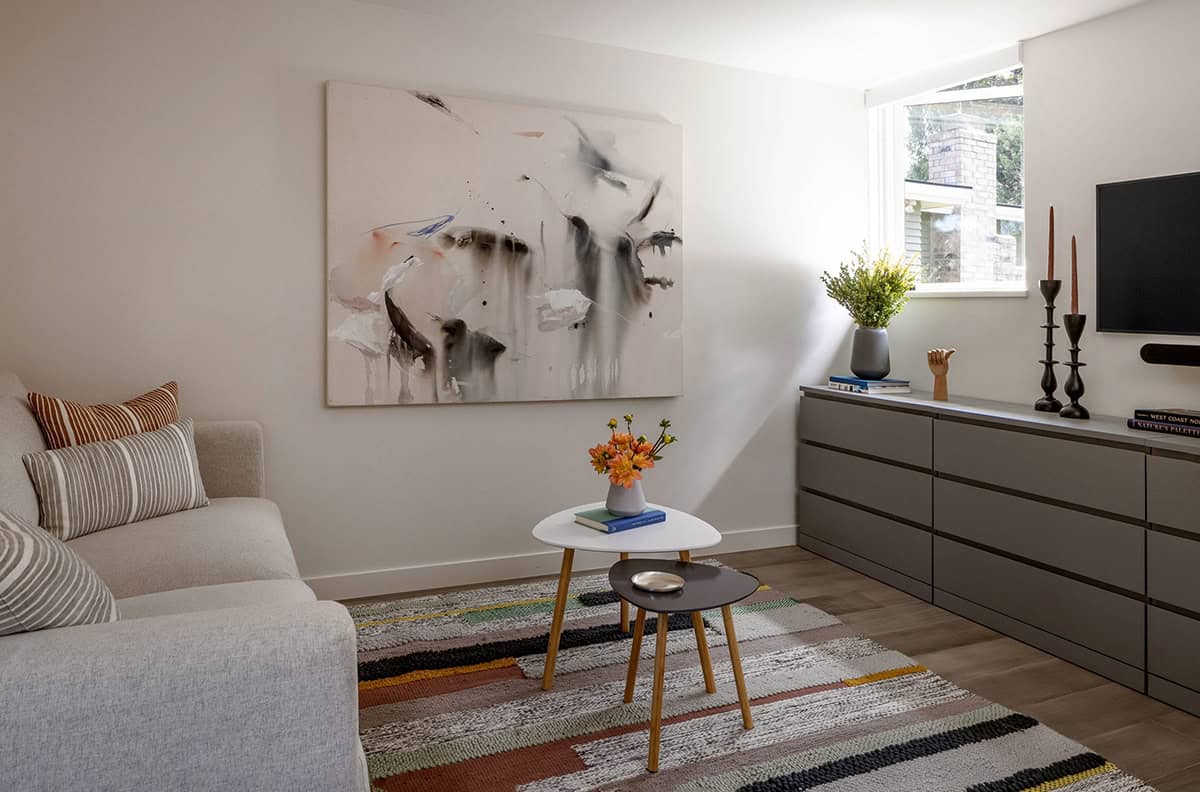 Sitting area with a beige sofa, abstract art, and a striped area rug