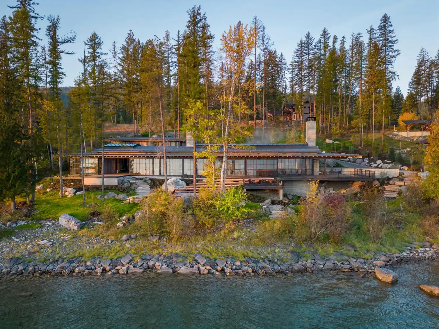Lakefront house nestled among pines with rocky shoreline