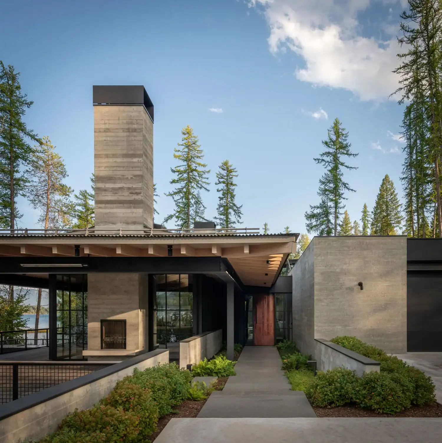 Concrete chimney and covered walkway leading to entry