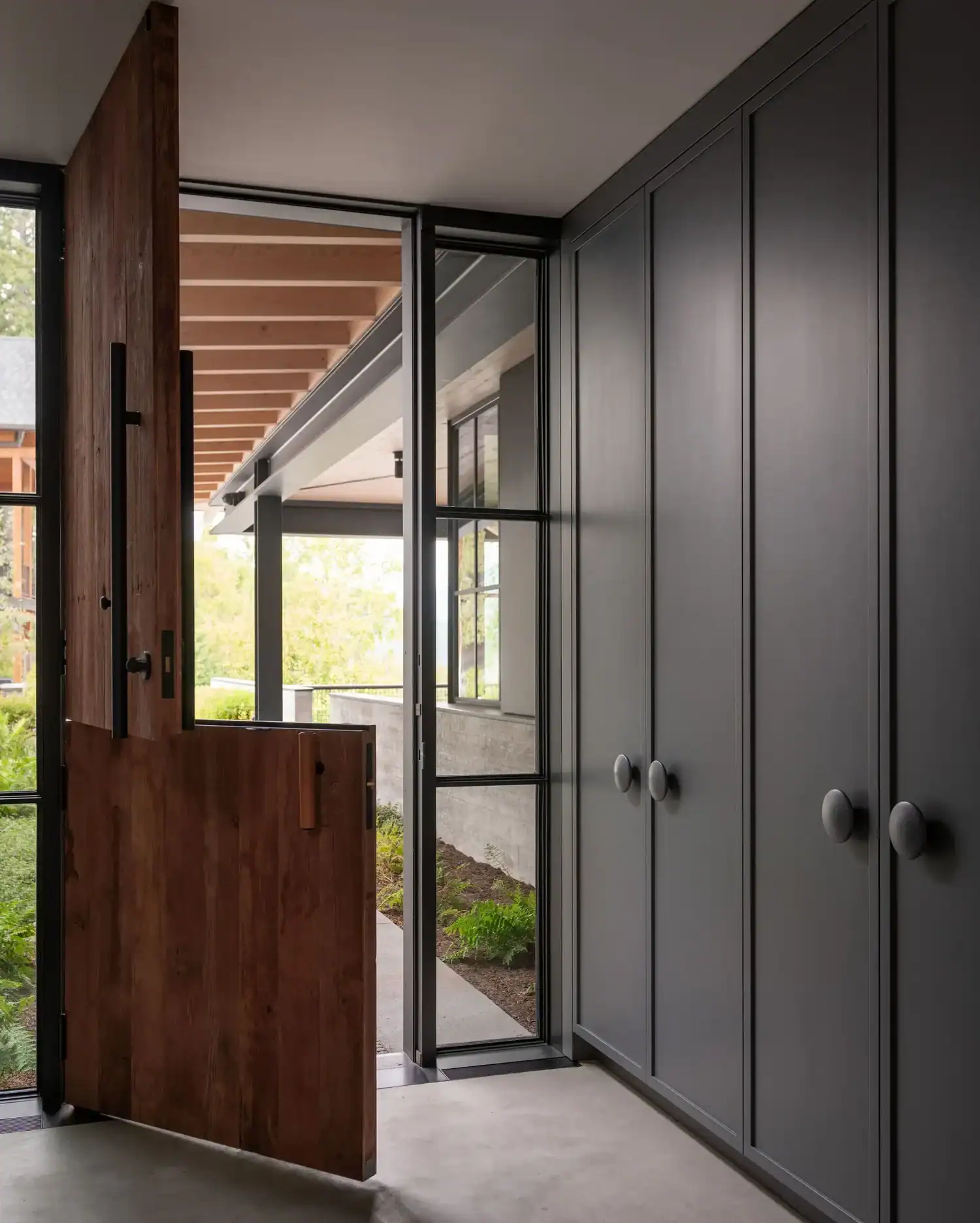 Mudroom with reclaimed wood Dutch door and gray cabinetry