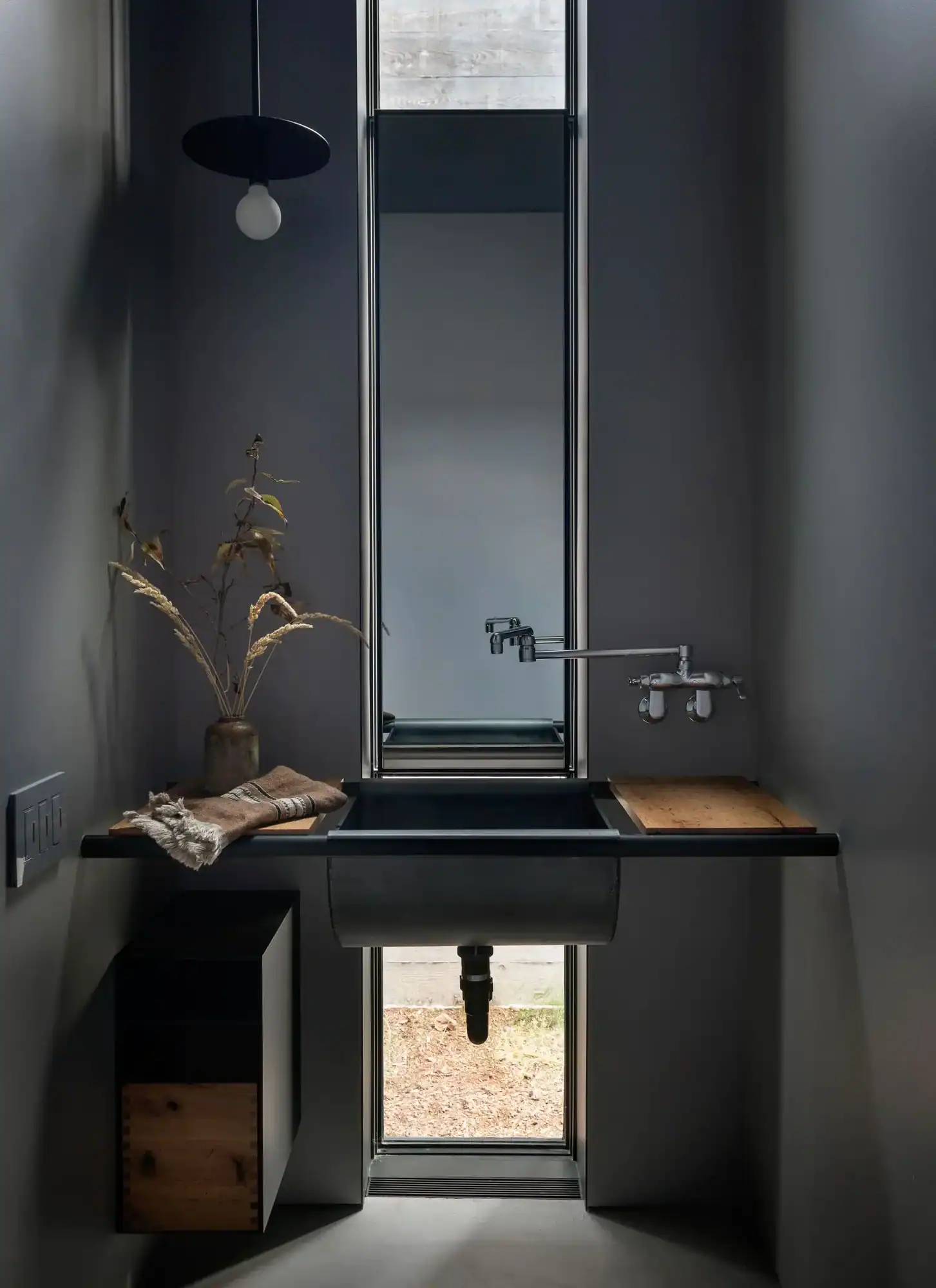 Dark powder room with industrial sink and wall-mount faucet