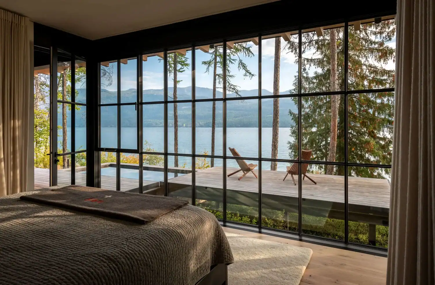 Bedroom with floor-to-ceiling windows overlooking the pool