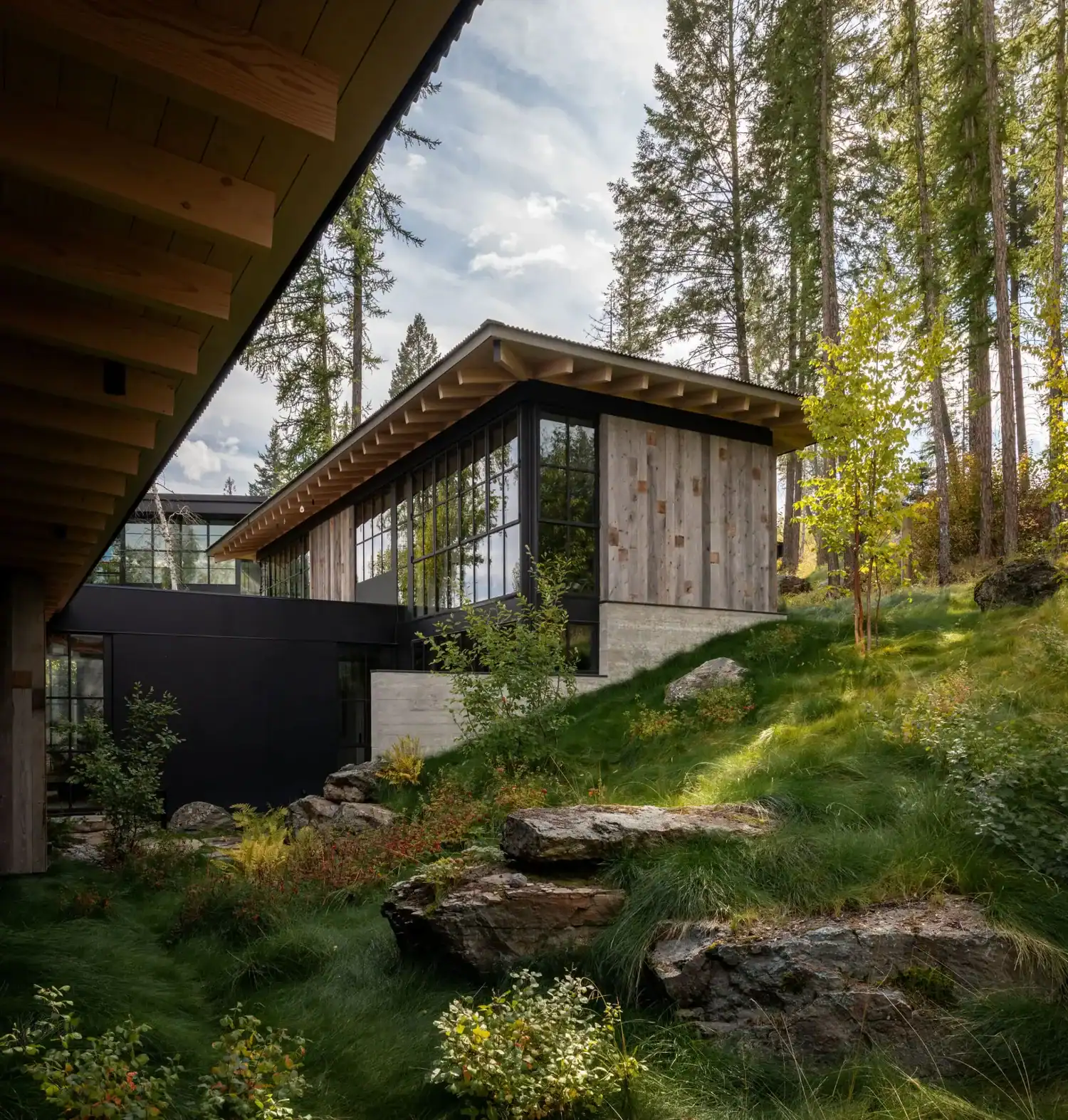 Exterior corner with reclaimed wood siding and grassy hillside