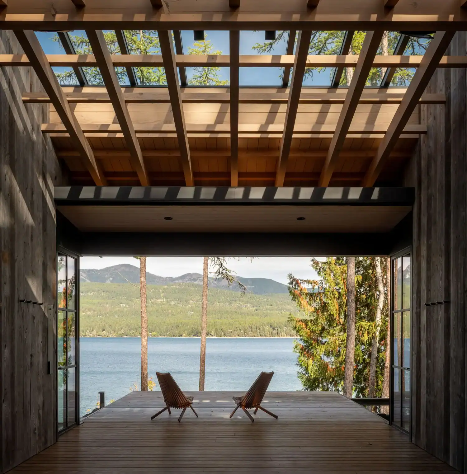 Covered deck framed by wood beams overlooking the lake
