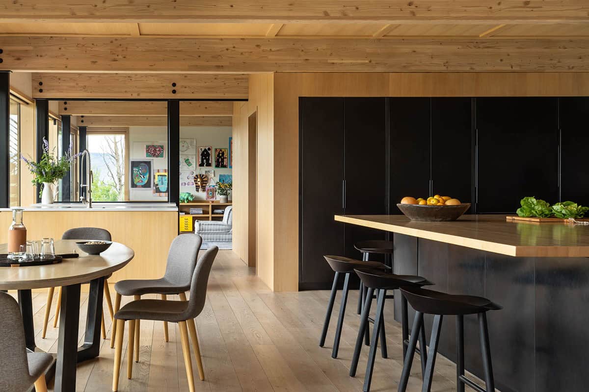 Kitchen with black cabinetry, wood island, and round dining table