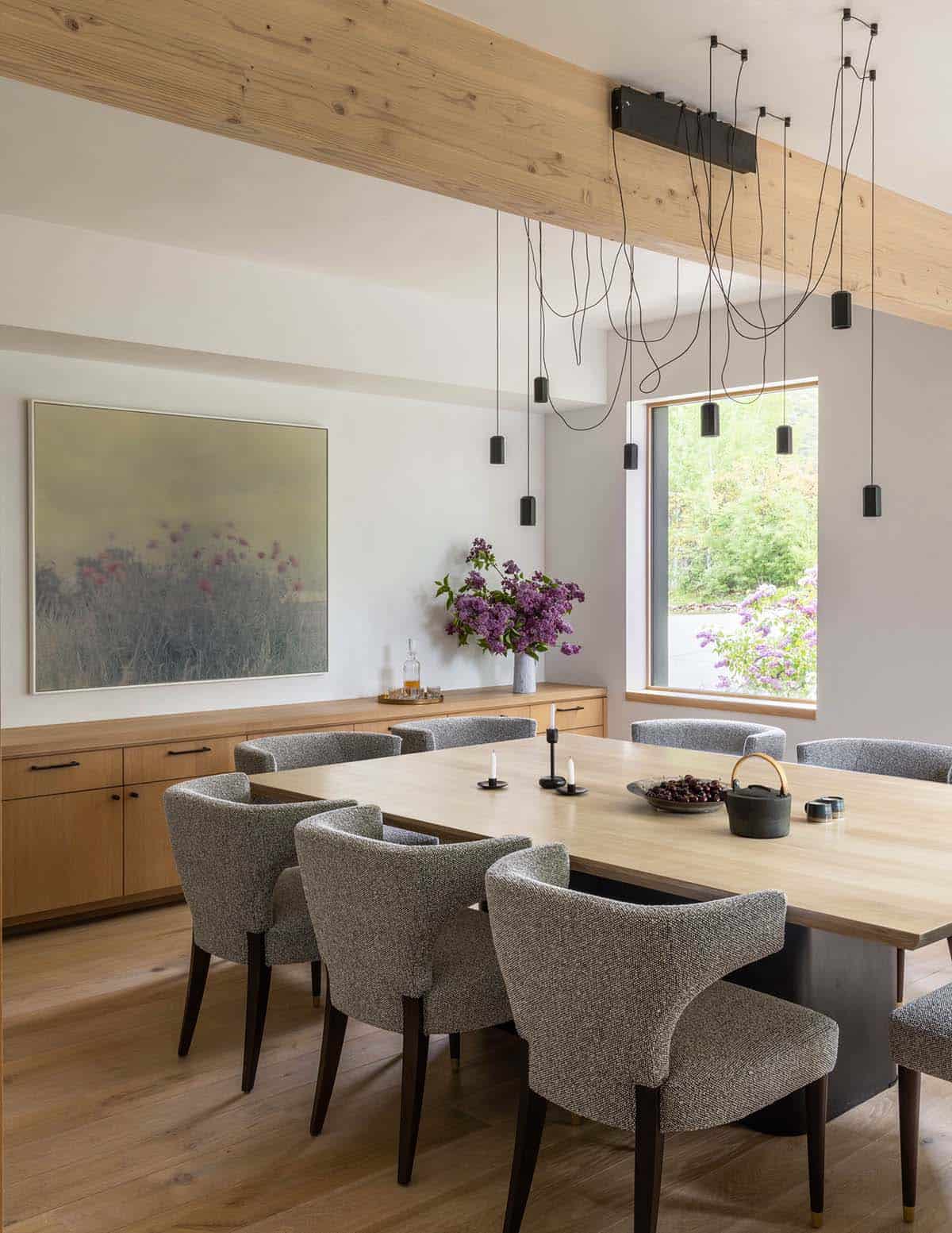 Dining room with wood table, gray upholstered chairs, and hanging pendant lights