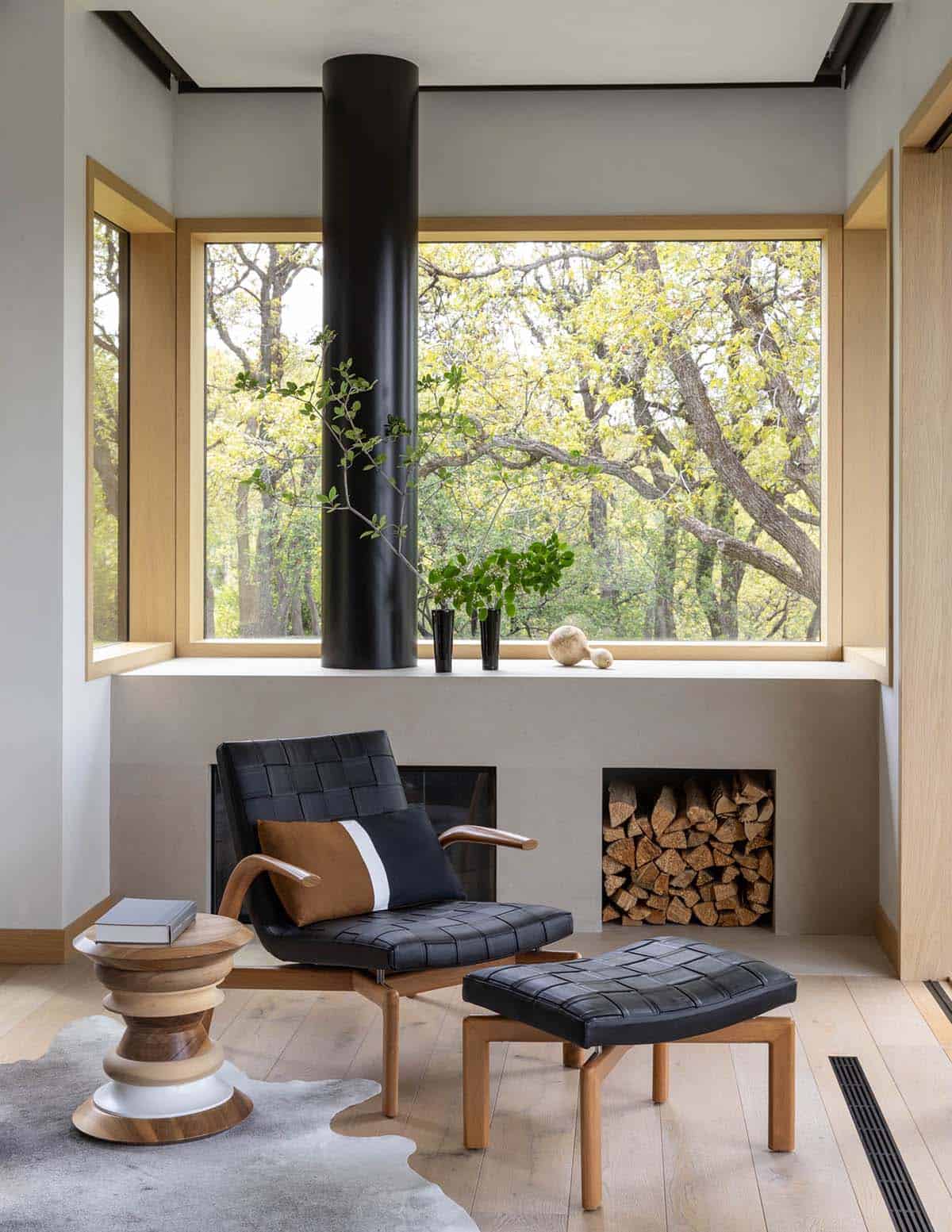 Cozy reading nook with black leather chair, ottoman, and built-in firewood storage
