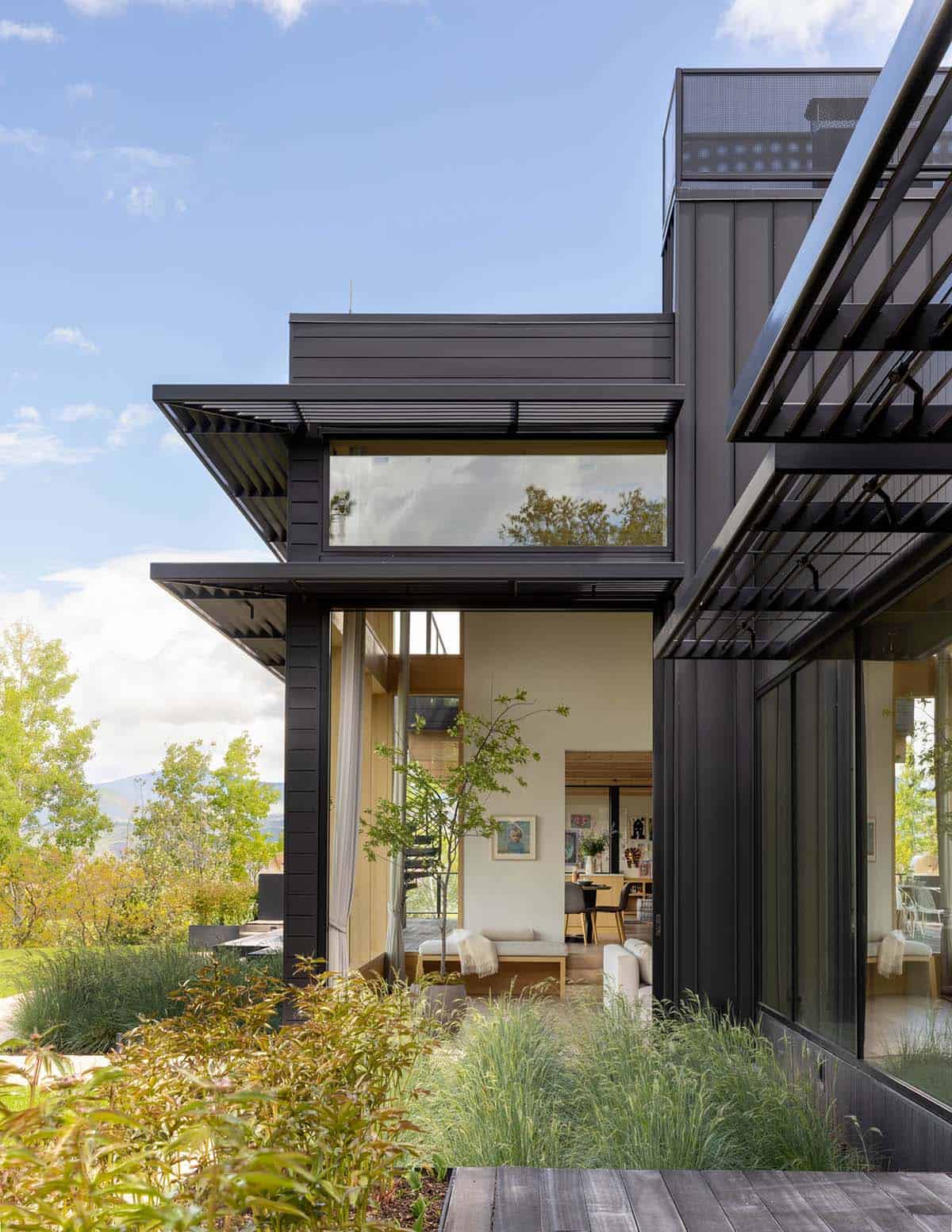 Close-up of black paneled exterior with covered walkway and glimpse of interior art