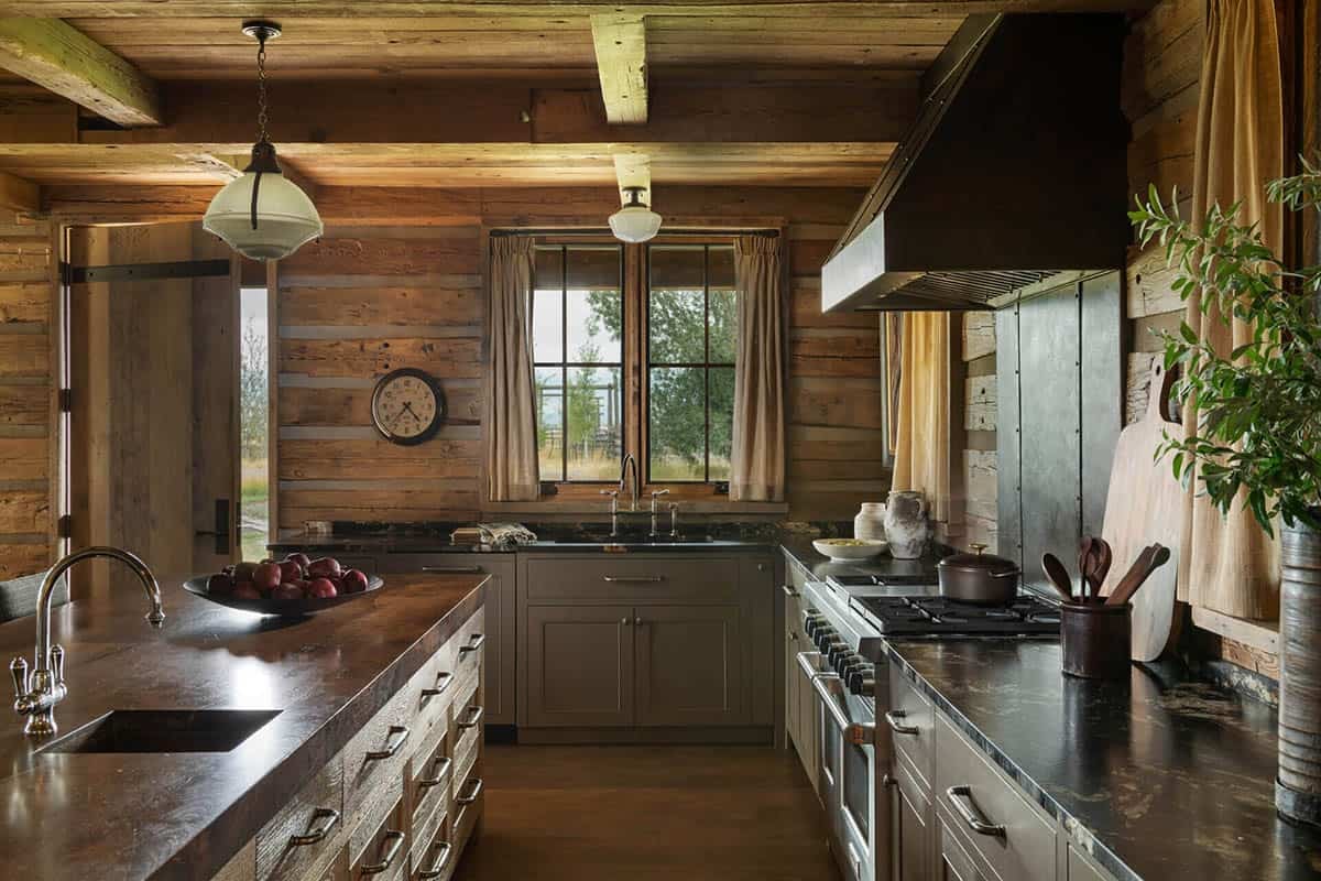 Kitchen corner with dark stove hood, log walls, and window over the sink