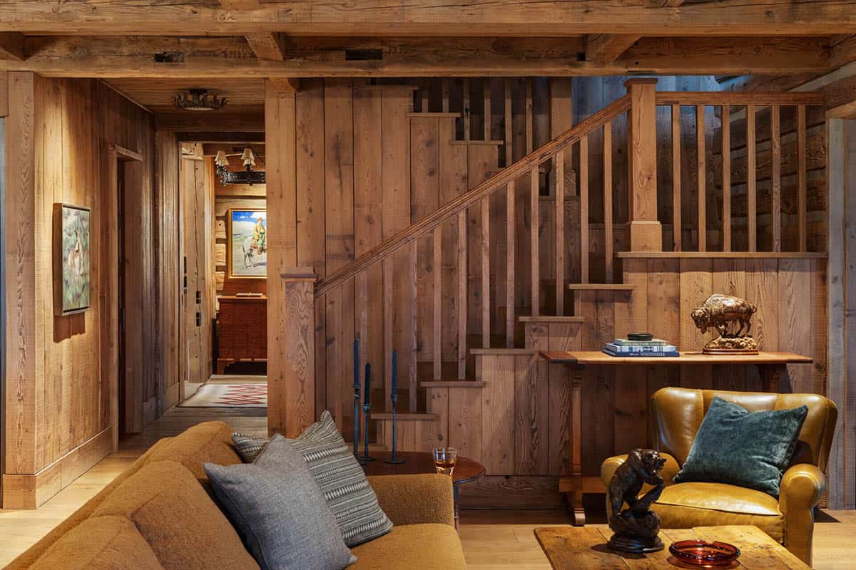 Wood-paneled staircase and sitting area with leather armchair and bronze bison sculpture