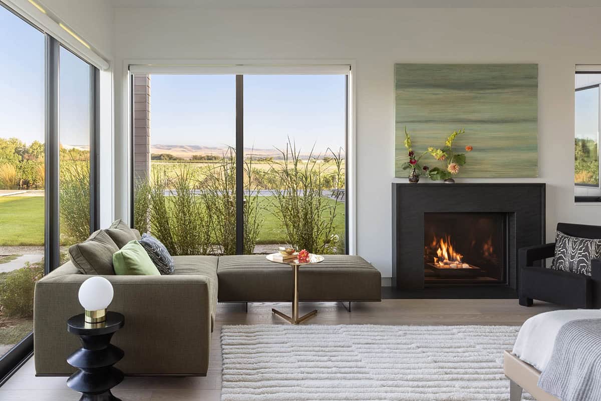 Bedroom sitting area with fireplace and floor-to-ceiling windows