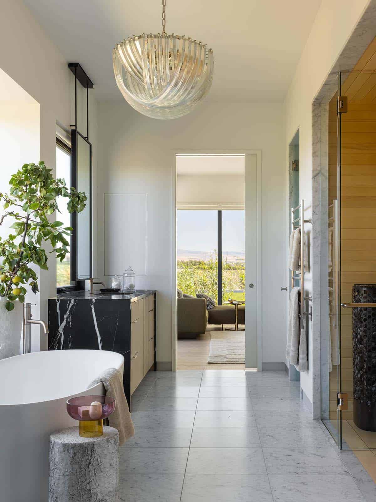 Bathroom with freestanding tub, marble vanity, and sauna entrance