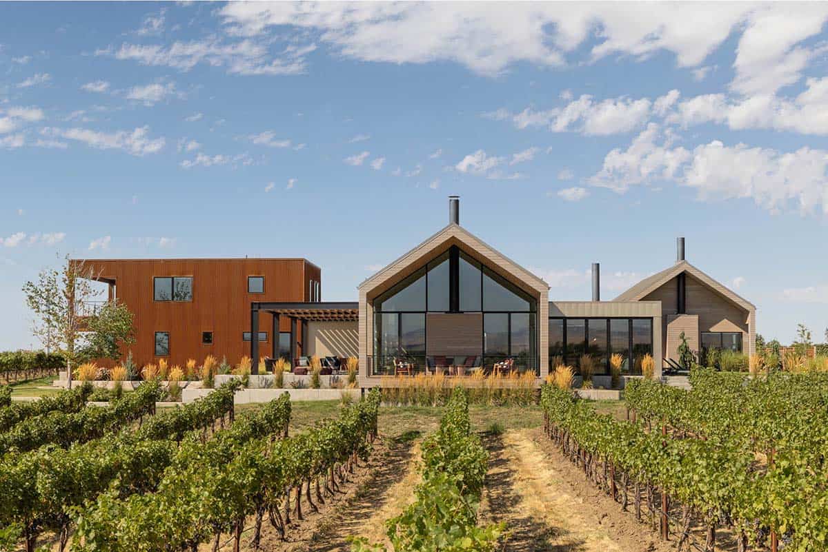 Aerial view of vineyard home with gabled wings and rusted metal volume