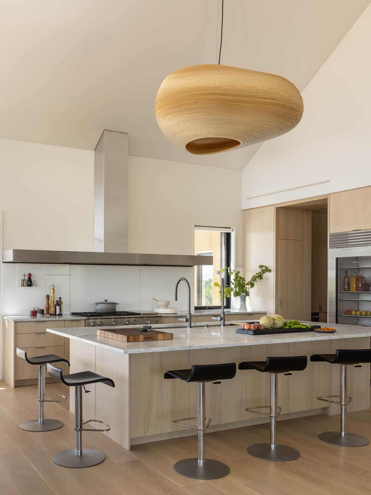 Kitchen island with oversized woven pendant light and bar stools