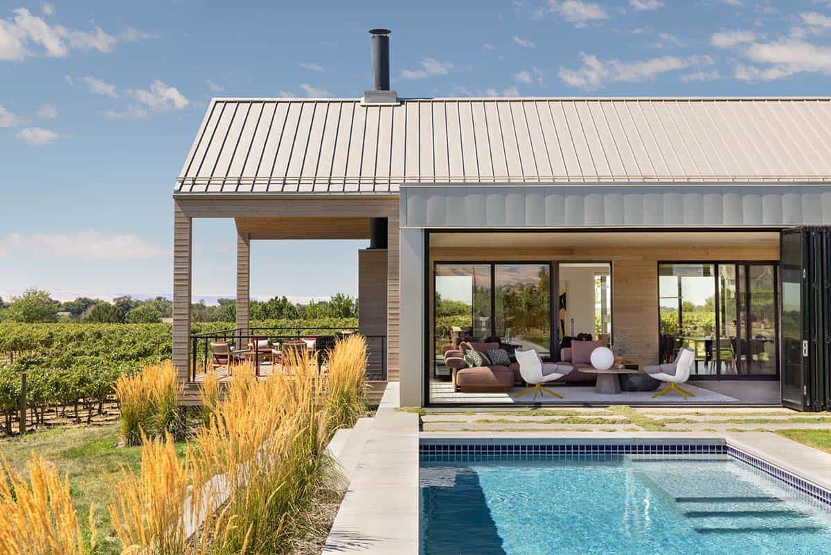 Rear exterior with pool, covered porch, and vineyard backdrop